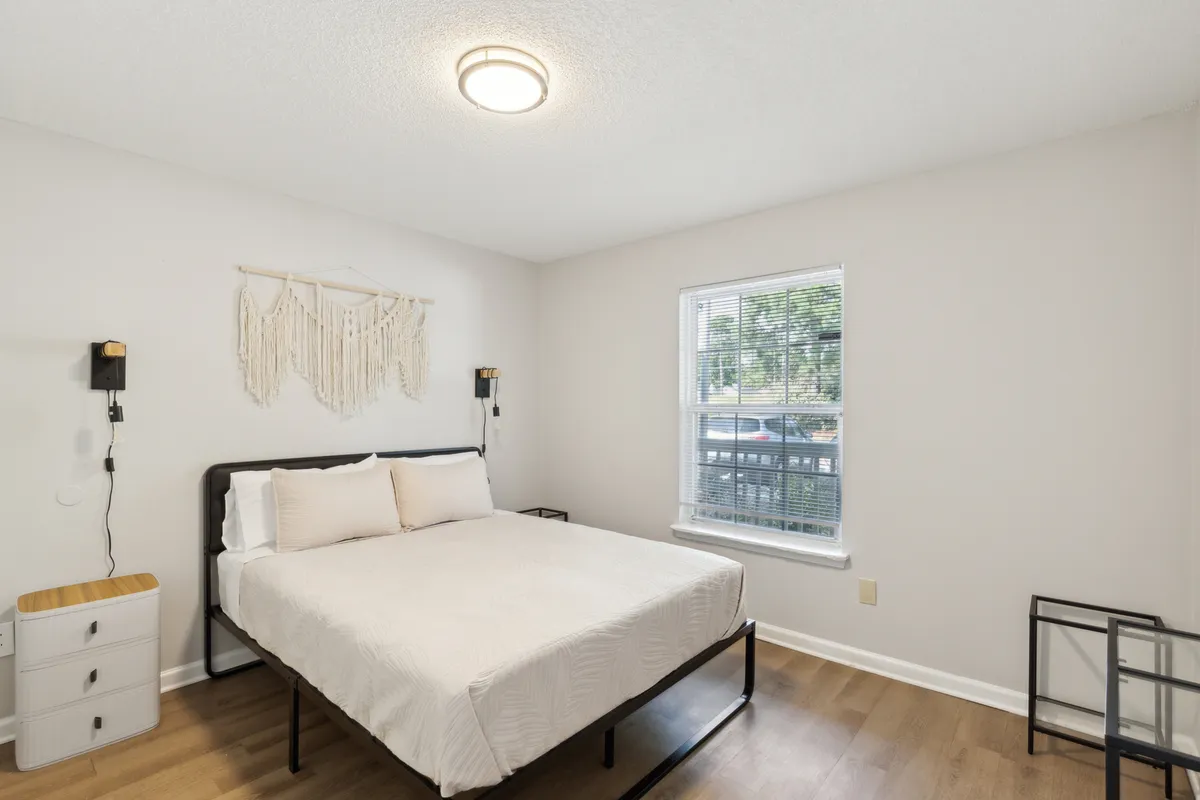 A peaceful bedroom featuring a comfortable bed, calming wall decor, and a sunlit window. The gentle light and uncluttered setting emphasize tranquility and the opportunity for a refreshing start to the day.